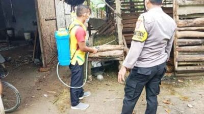 Bhabinkamtibmas Polsek Tanjung Pura Lakukan Penyemprotan di Lokasi Kandang Hewan Ternak Milik Warga