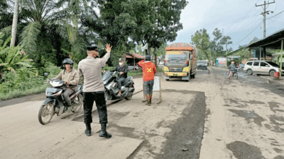 Personel Polsek Hinai Atur Arus Lalin dan Patroli Sehubungan Adanya Pengaspalan